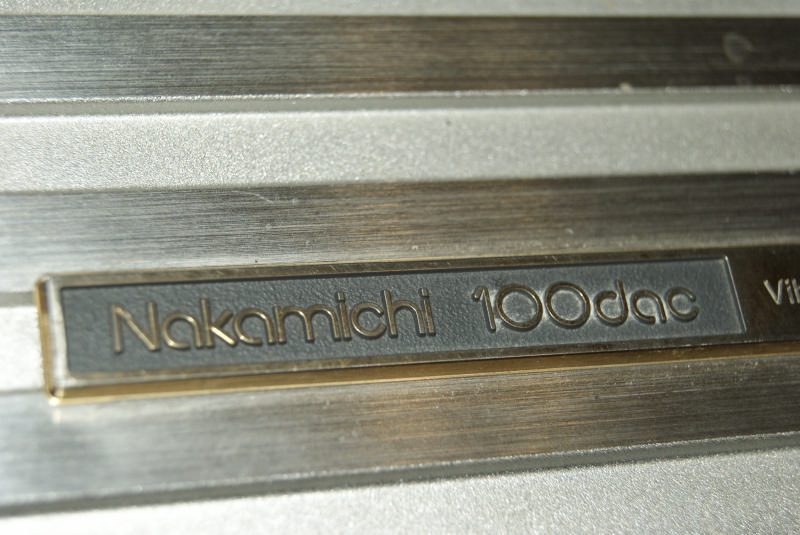 Золочёный шильдик Nakamichi 100dac на лицевой панели аппарата