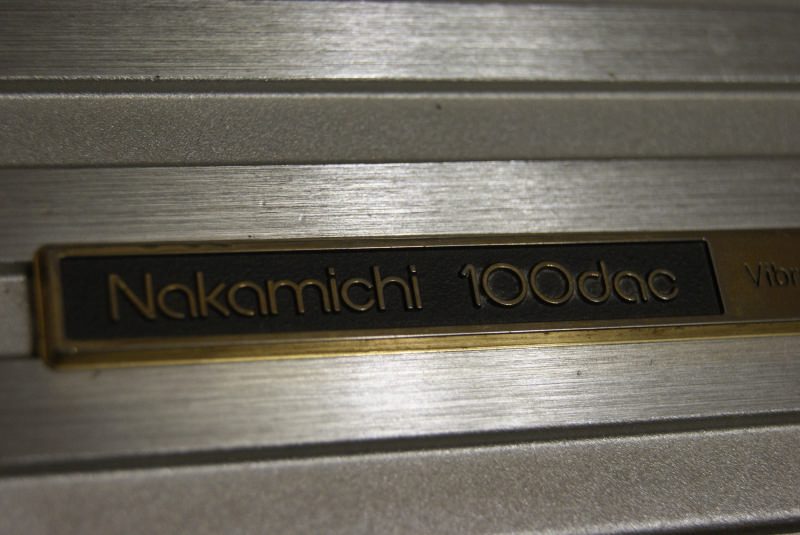 Крупный план гравировки Nakamichi 100dac и начала надписи Vibration Isolated System